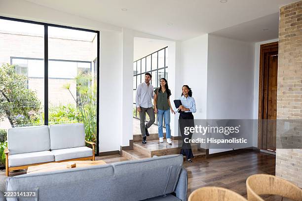 pareja mirando una casa en venta con un agente de bienes raíces - visita guiada de casa fotografías e imágenes de stock