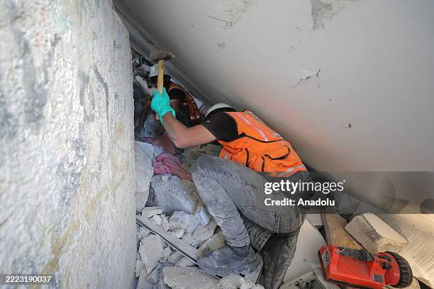 Civil defense members and Palestinian residents inspect the site and conduct search and rescue operation amid rubble of buildings after Israeli army...