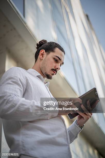 millennial startup founder using innovative digital tools on a tablet, making business tasks easier and more efficient- business technology, smart workflow, and entrepreneurial success - ana-morales stock pictures, royalty-free photos & images
