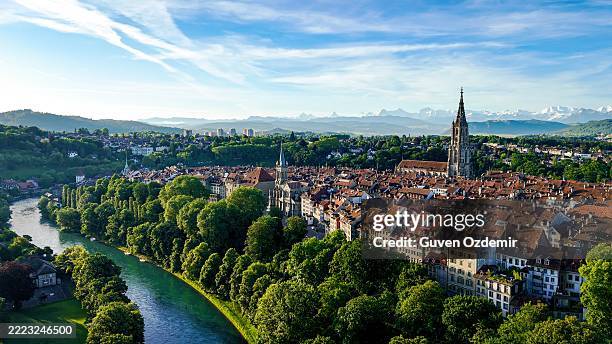 vue aérienne de la vieille ville de berne avec berner münster et l’aar serpentant à travers un paysage verdoyant, un site classé au patrimoine mondial de l’unesco et un monument culturel sous un ciel d’été dégagé dans la capitale de la suisse - canton de berne photos et images de collection