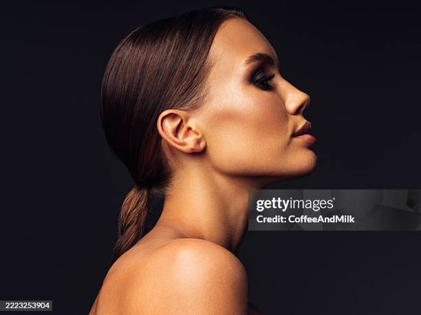 side profile portrait of woman with sleek hair and elegant features - ponytail stock pictures, royalty-free photos & images