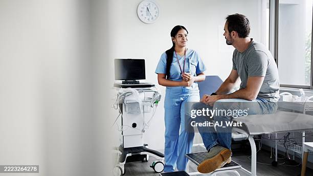 infirmière consultant un patient dans la salle d’examen de l’hôpital pendant le rendez-vous - blouse dexamen médical photos et images de collection