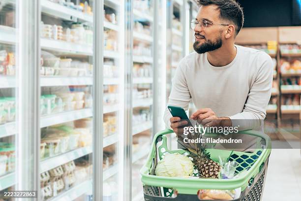 handsome man shopping in supermarket - buy online pick up in store stock pictures, royalty-free photos & images