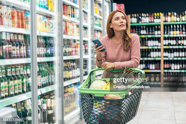 woman shopping in supermarket. - buy online pick up in store stock pictures, royalty-free photos & images