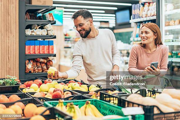 couple shopping in supermarket. - buy online pick up in store stock pictures, royalty-free photos & images
