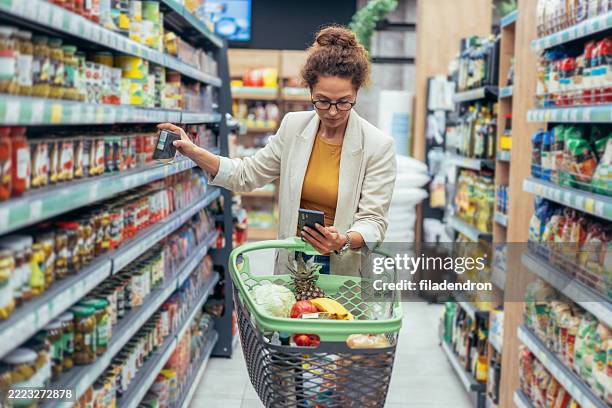 woman shopping in supermarket. - buy online pick up in store stock pictures, royalty-free photos & images