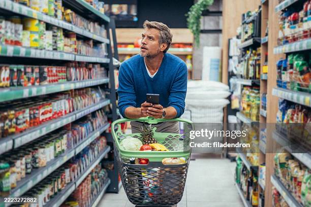 handsome man shopping in supermarket - buy online pick up in store stock pictures, royalty-free photos & images