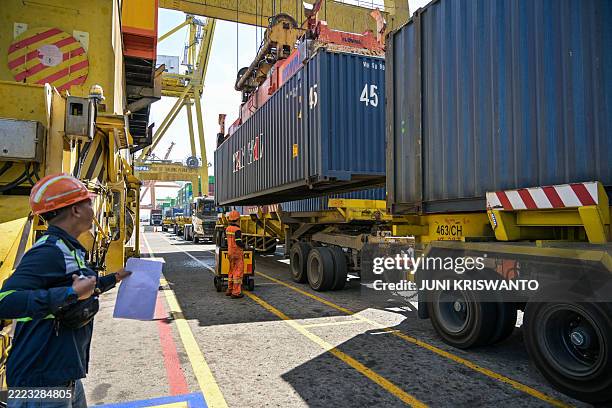 Containers are loaded on a container ship at the International Container Terminal in Surabaya on July 7, 2025. While US President Donald Trump...