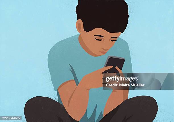 focused boy using smart phone against blue background - adolescence stock illustrations