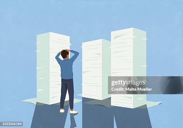 overwhelmed man with hands on head looking at large stacks of paperwork - information overload stock illustrations