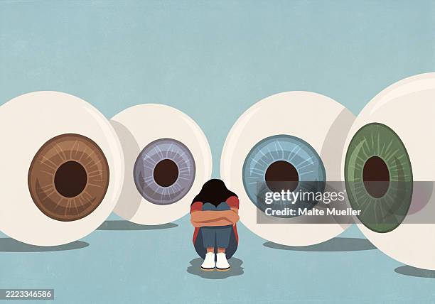 large multicolored eyeballs staring at woman trying to hide with head down and arms wrapped - judgement stock illustrations