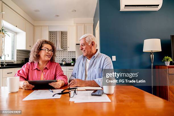 senior couple talking and doing home finance - financial planning stock pictures, royalty-free photos & images