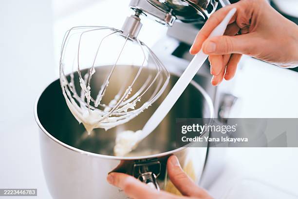 hands preparing a mixture using a kitchen stand mixer in a modern kitchen - stand mixer stock pictures, royalty-free photos & images