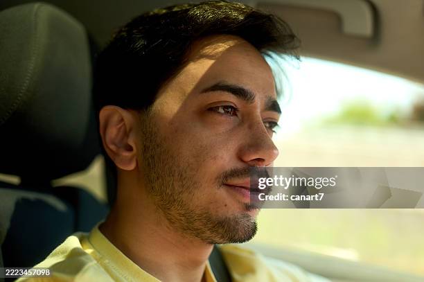 jeune homme adulte conduisant à la lumière du jour - appuie tete voiture photos et images de collection
