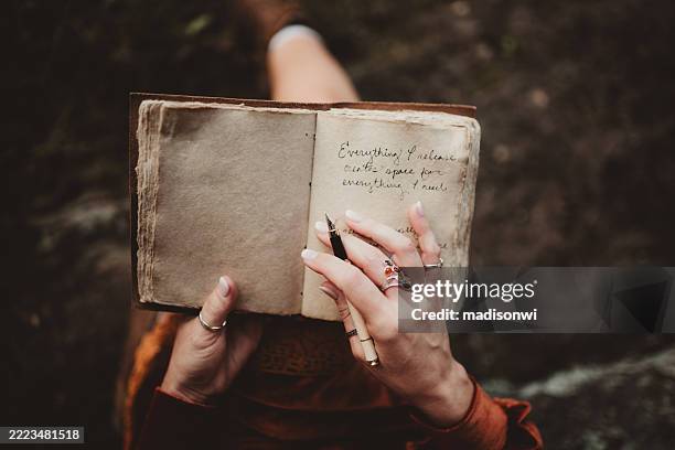woman writing in her journal or diary sitting outdoors - dagbok bildbanksfoton och bilder