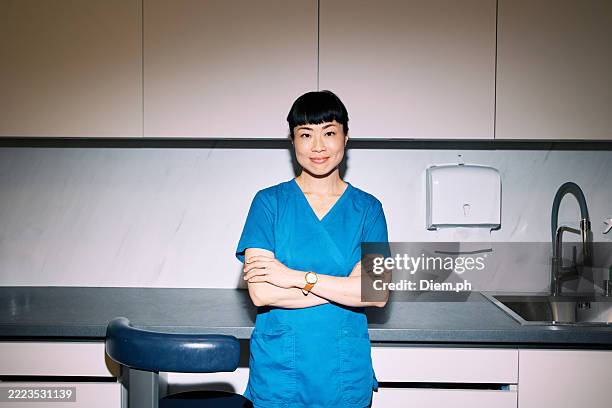 selbstbewusste japanische zahnärztin in moderner klinik - zahnarzthelfer stock-fotos und bilder