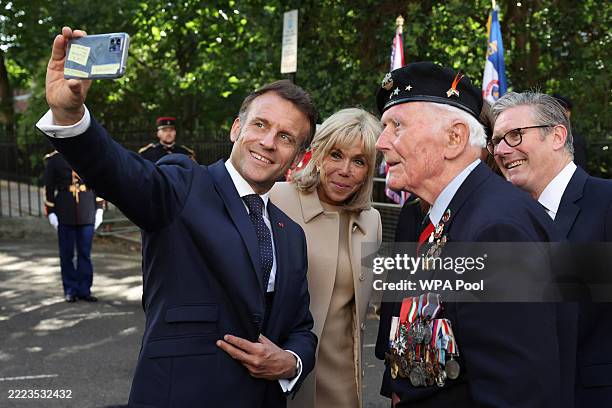 French President Emmanuel Macron takes a selfie on a smartphone with his wife Brigitte Macron, Britain's Prime Minister Keir Starmer and Veteran...