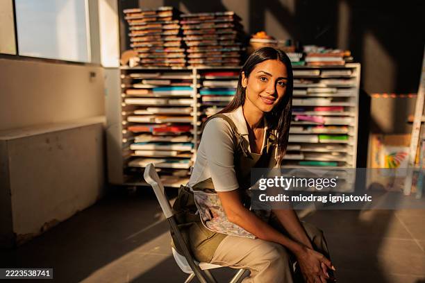 confident woman painter in her art-filled workshop - artist stock pictures, royalty-free photos & images