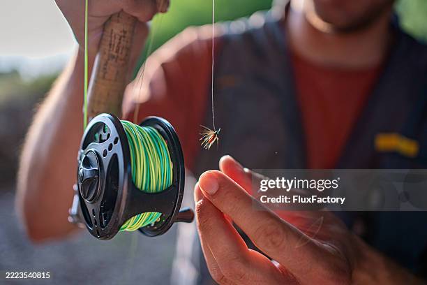 father and daughter fly fishing with a trout in a scenic river setting - highlight reel stock pictures, royalty-free photos & images