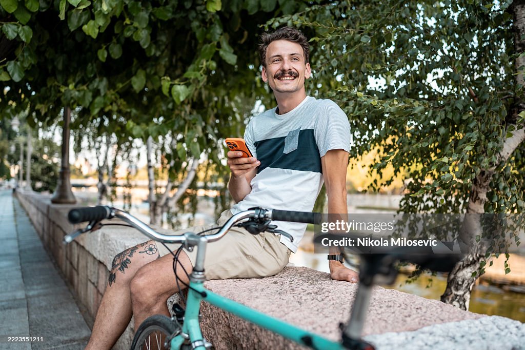 Man Enjoying a Relaxing Moment Beside His Bicycle Outdoors