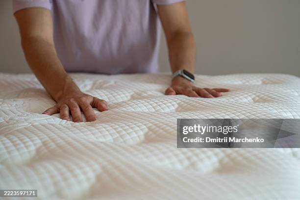 man hands testing pressing on new mattress to check comfort level firmness and material quality - mattress stock pictures, royalty-free photos & images