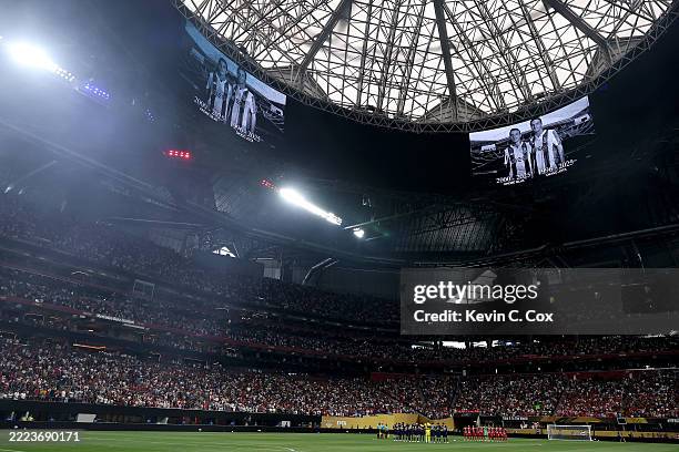 Players of FC Bayern München and Paris Saint-Germain line up to observe a moment of silence in tribute to football players Diogo Jota and his brother...
