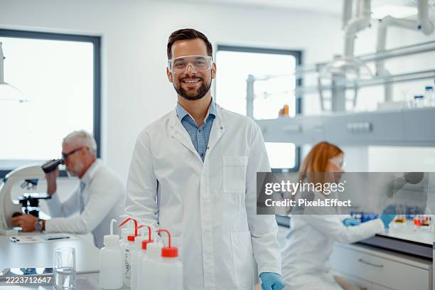 happy male scientist in modern research lab environment - scientist portrait stock pictures, royalty-free photos & images