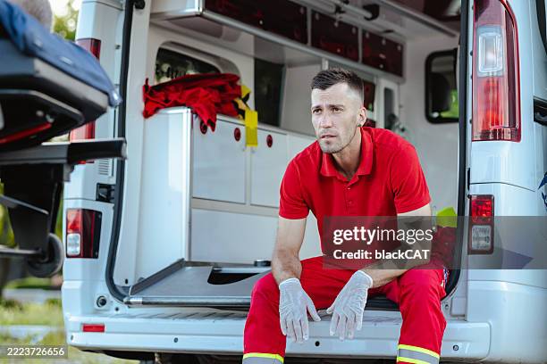 paramedic taking a break outside an ambulance during a work shift - shift work stock pictures, royalty-free photos & images