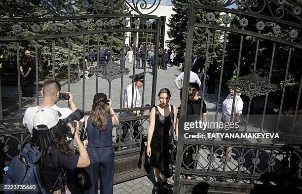 Journalists film outside the gates during a farewell ceremony in memory of former Russia's former transport minister Roman Starovoyt, who died...