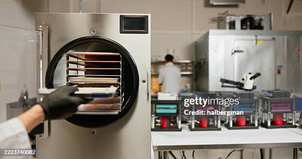 behandschuhte hand nimmt haschisch aus dem gefriertrockner, kolophonium drückt im hintergrund - vakuumkammer stock-fotos und bilder