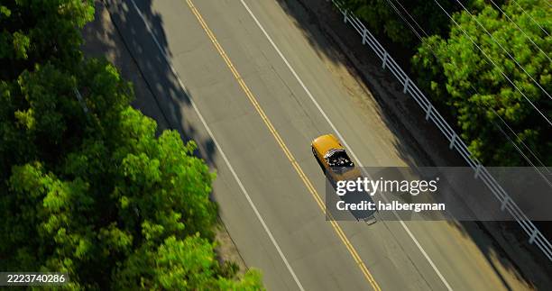 overhead aerial view of vintage convertible on a single lane road on a sunny day - carro de coleccionador imagens e fotografias de stock