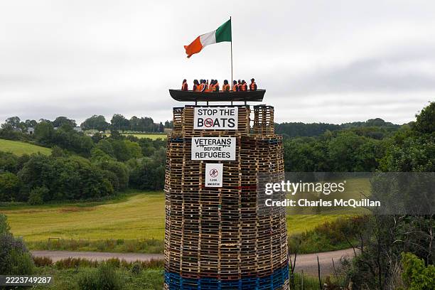 Model of a small boat with several figures depicting migrants inside can be seen on top of a loyalist bonfire on July 10, 2025 in Moygashel, United...
