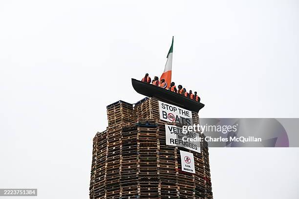 Model of a small boat with several figures depicting migrants inside can be seen on top of a loyalist bonfire on July 10, 2025 in Moygashel, United...