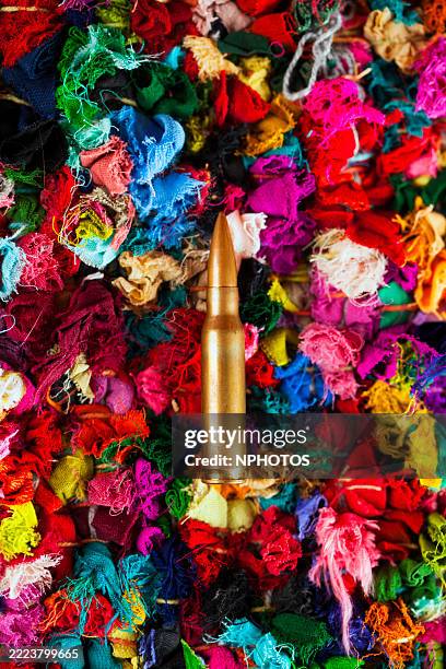 close up of old pieces of colorful fabric with a bullet - war torn stock pictures, royalty-free photos & images