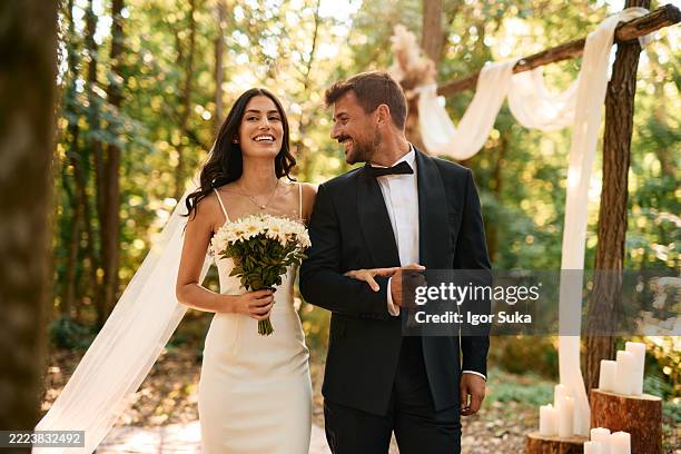 pareja feliz caminando por el pasillo en la ceremonia de boda al aire libre en el bosque - boda fotografías e imágenes de stock