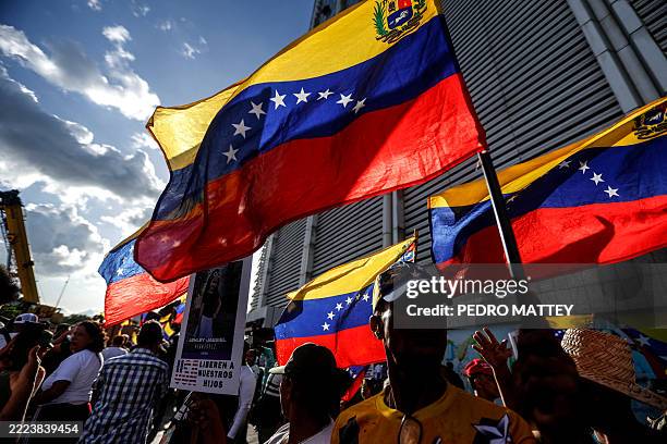 Supporters of the Venezuelan government hold the national flag during a demonstration for children who remain in the US after being separated from...