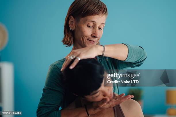 chiropractor performing spinal manipulation on patient's neck - chiropractic office stock pictures, royalty-free photos & images