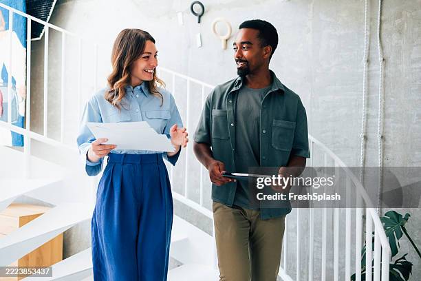 professionals discussing work in a modern creative office environment - business casual stock pictures, royalty-free photos & images