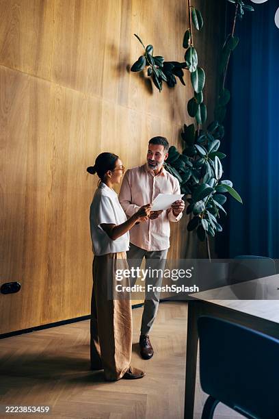zusammenarbeit zwischen kollegen in einer modernen büroumgebung - verkaufsargument stock-fotos und bilder