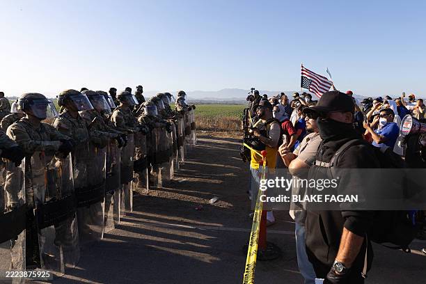 California National Guard troops face off with protestors during a Federal Immigration raid on Glass House Farms in Camarillo, California, July 10,...