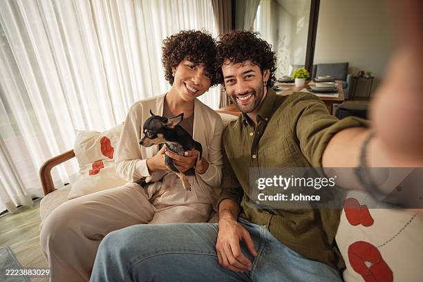 couple taking selfie with dog at home - camera point of view stock pictures, royalty-free photos & images
