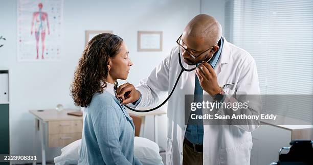 woman, doctor and listen with stethoscope at clinic for chest exam, respiratory virus and asthma. man, patient and medical tools with breathe problem, health assessment or lung capacity for diagnosis - lunga bildbanksfoton och bilder