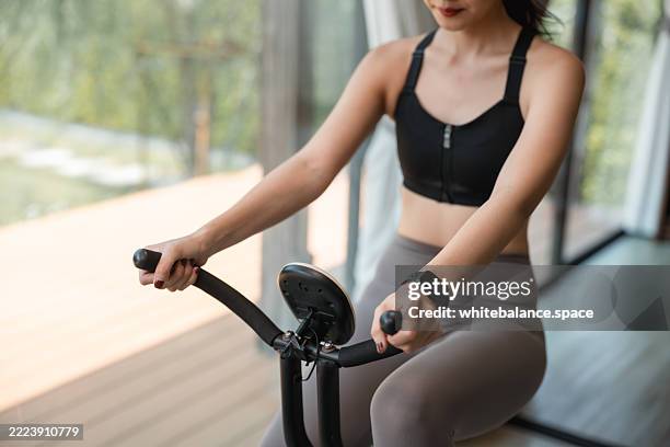 sporty young woman doing gym cycling at home - exercise bike stock pictures, royalty-free photos & images