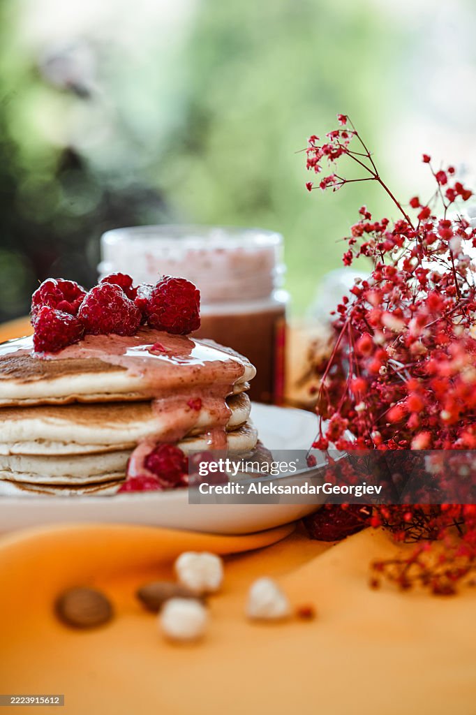 Goldene Pfannkuchen mit Himbeermarmelade und saftigen Beeren zum Genießen