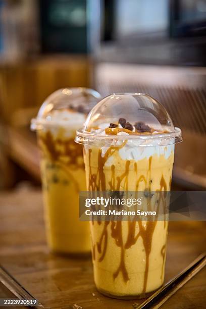 a mango graham shake in a clear plastic cup. - mango shake stock pictures, royalty-free photos & images