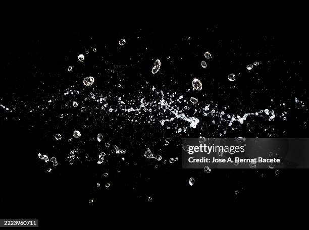 splashes of moving water on a black background. - splashing droplet stock pictures, royalty-free photos & images