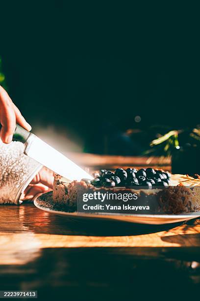 cutting a festive homemade blueberry cheesecake - hygge stockfoto's en -beelden
