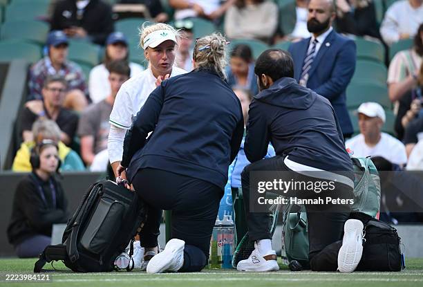 Clara Tauson of Denmark speaks to staff during a medical time-out against Iga Swiatek of Poland during the Ladies' Singles fourth round match on day...