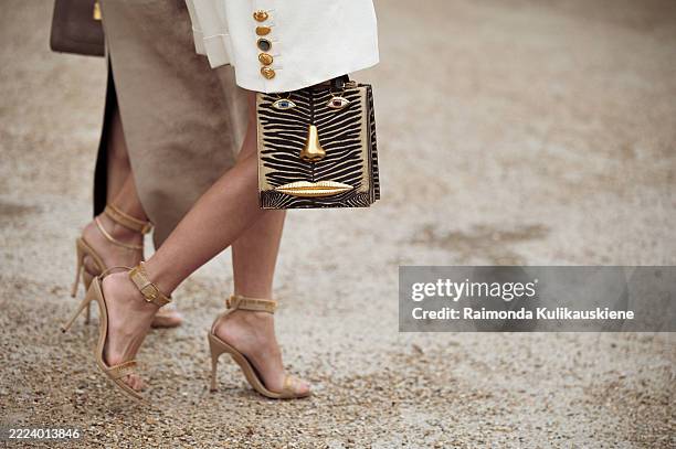 Tiffany Hsu wears white skirt, white jacket, black and gold bag and golden high heels and Tina Leung wears a beige suede skirt, nude ankle-strap...