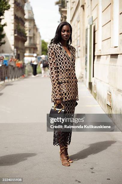Guest wears golden suit out of long sleeve jacket and pencil skirt outside Rahul Mishra during the Haute Couture Fall/Winter 2025/2026 as part of...